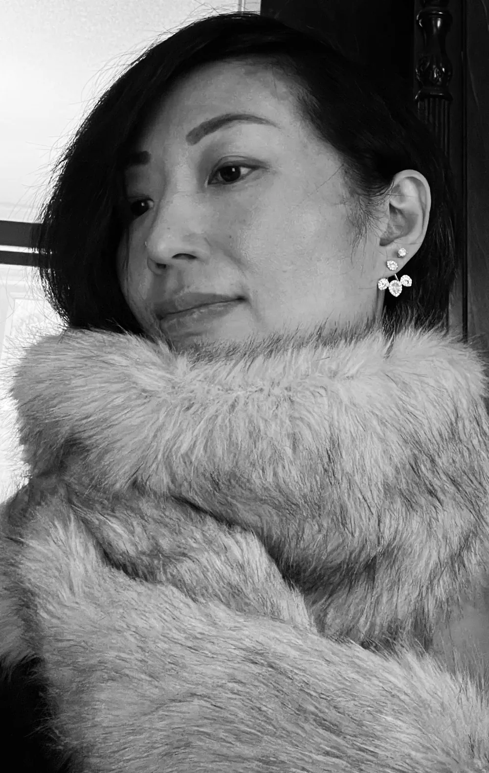 Anita Tong in a close portrait, a fur collar turned up around her face