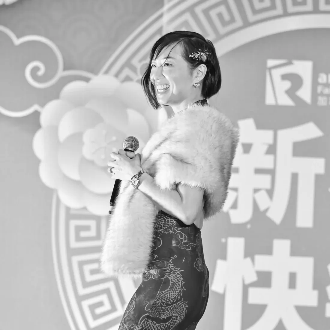 Anita Tong chantant lors d’une célébration du Nouvel An lunaire, étole de fourrure sur un qipao à motifs