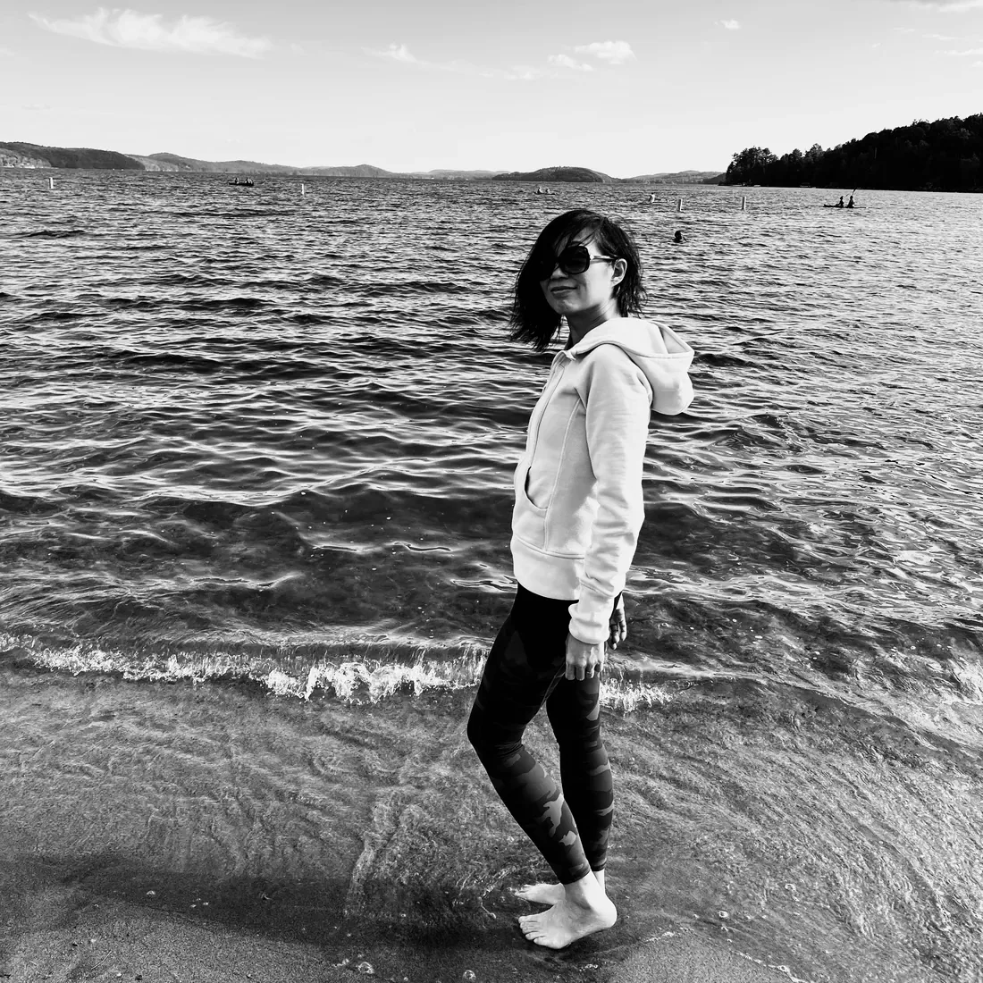 Anita Tong dans l’eau jusqu’aux chevilles, des collines de l’autre côté du lac