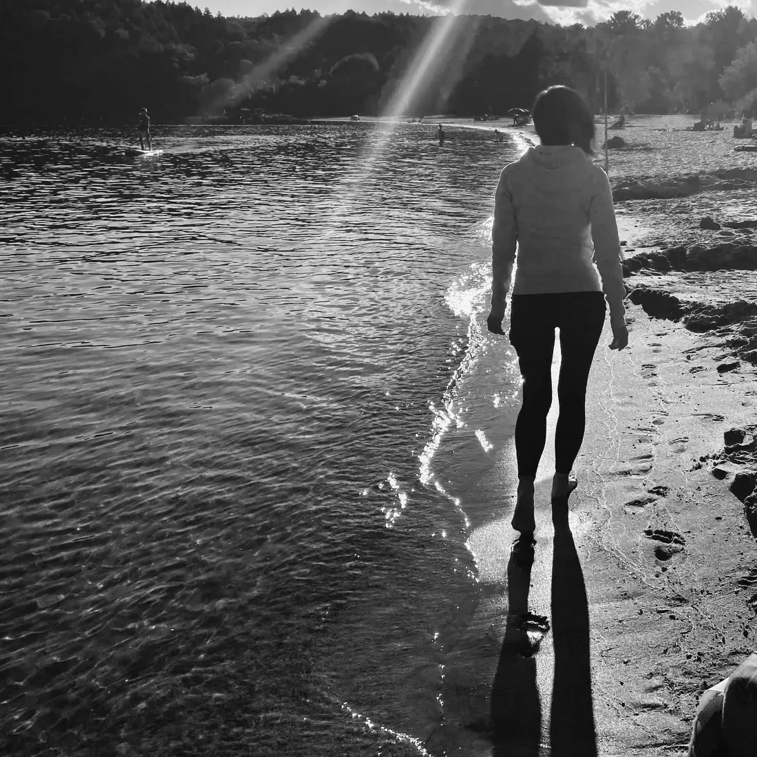Anita Tong s’éloignant au bord de l’eau, le soleil scintillant sur le lac