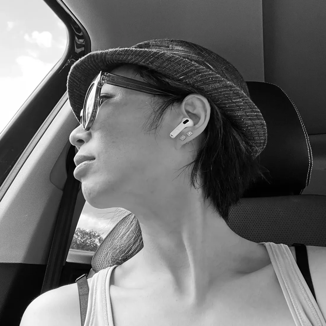 Anita Tong de profil, casquette plate et lunettes teintées